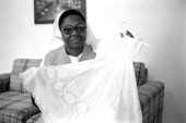 Sister Rouby Balmas displaying the christening dress she made - Miami, Florida.