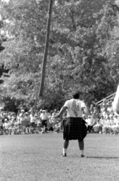 Man participating in "turning the caber" at Scottish games