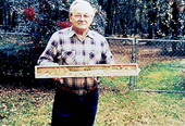 Man holding up a piece of wood-carving