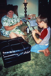 Woman teaching a boy how to weave