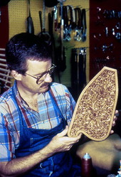 Man holding up a piece of wood-carving