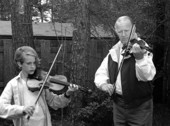 Apprentice Andrew Cook learning the art of twin fiddling from his mentor George Custer.
