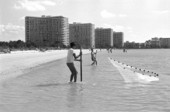 Two boys pulling in a cast net they are fishing with