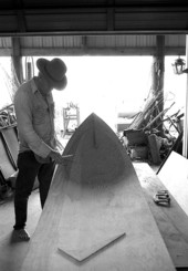 Glen Simmons looking over an Everglades skiff that he and an apprentice are making- Florida City, Florida.
