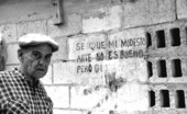 Folk Heritage Award winner Mario Sanchez standing with one of his bas-relief sculptures- Key West, Florida.