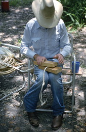 Cow whip maker George "Junior" Mills rolling a whip between blocks of wood - Okeechobee, Florida.