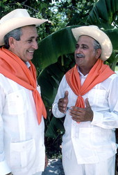 Cuban guajiro apprentice, Mario Brito, left, smiles as Meliton Perdomo sings a decima - Medley, Florida.