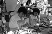 Fu Yung Chang of Gainesville, left, demonstrating rice dough figure making at the 1986 Florida Folk Festival - White Springs, Florida