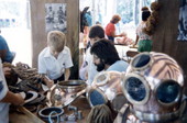 Nick Toth with display of Greek deep sea diving helmets at the 1986 Florida Folk Festival - White Springs, Florida