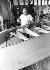 Boatbuilder Bobby Shiver checking a dimension on the oyster skiff that he is building - Eastpoint, Florida