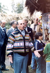 Secretary of State George Firestone trying on Seminole patchwork jacket.