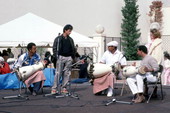 Ernesto Pichardo, standing, and Bata drummers performing at Historical Museum of Southern Florida during Traditions Festival - Miami, Florida.