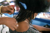 Woman having her hair braided at the Traditions Festival - Miami, Florida