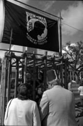 People talking to Vietnam veteran in a cage on the Veterans Day POW-MIA parade float in Tallahassee.