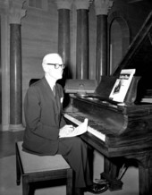 Geoffrey O'Hara sitting at a piano