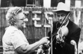 Fiddler Zeke Stephens performing at the Florida Folk Festival while his wife Rosa beats the strings to carry the rhythm.