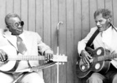 Rev. N.L. Williams, left, playing blues guitar while "Blind" Johnny Brown plays a resonator guitar for a field tape.