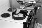 Flora Mae Hunter demonstrates cooking rice cakes.