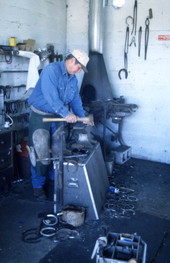 View showing farrier Randy Minger working on a horseshoe at the Spring Garden Ranch Training Center in De Leon Springs, Florida.