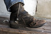 Close-up view showing the lace-up boot and spur of Doyle Rigdon.
