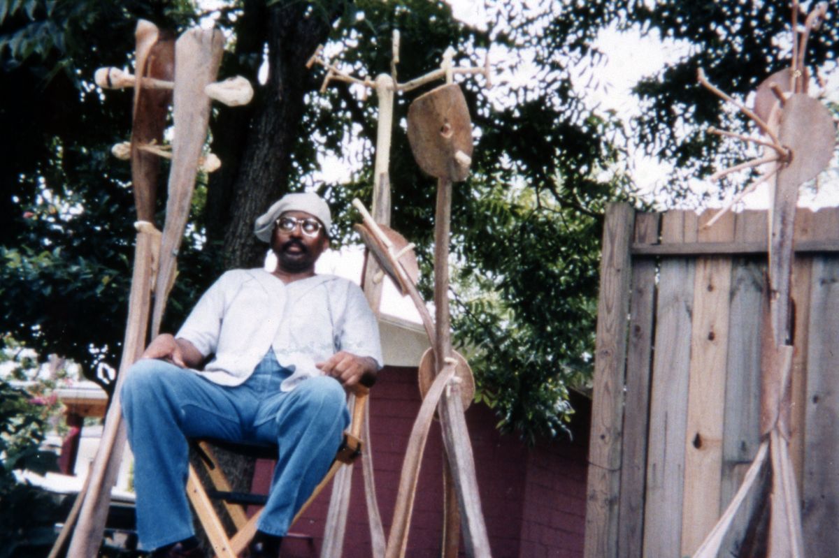 Eugene Cobb sitting among his sculptures in his backyard - Eatonville, Florida.