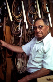 Whip maker, Claude Sheppard, standing by his collection of whips - Gainesville, Florida.