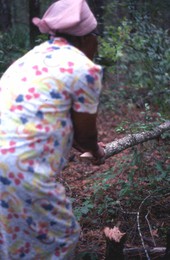 Lucreaty Clark grasping the white oak tree she chopped down to make baskets