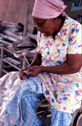 Lucreaty Clark preparing strip of white oak for basket making