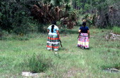 Claudia C. John walking with her mother Mary B. Billie in search of palmetto fibers to make dolls - Big Cypress Reservation, Florida