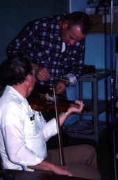 Harold Sconyers fiddling while Buddy Huggins "banjos" on the strings - Lake City, Florida.