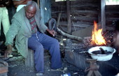 Blacksmith Thomas Rains at work while others look on - Jefferson County, Florida