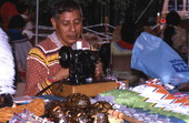 Seminole man sewing, with turtle shell rattles in front of him - White Springs, Florida