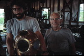 Nick Toth holding a Greek diving helmet while Antonios Lerios looks on - Tarpon Springs, Florida
