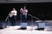 Nikitas Tsimouris playing a tsambouna while his son Tony claps along - White Springs, Florida