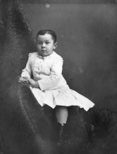 Child in skirt, stockings, and boots.