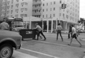 Citizens moving garbage dumpster left in the street by anti-war protesters during a rally in Miami Beach, Florida.