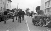 View showing protesters and an overturned garbage dumpster in the street during anti-war protests in Miami Beach, Florida.