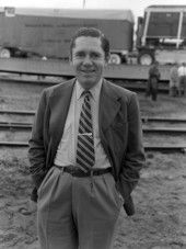 Portrait of John Ringling North, vice-president of the Ringling Circus, standing near the train leaving the winter quarters in Sarasota, Florida.