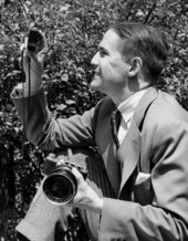 Portrait of Sarasota photographer Joe Steinmetz with his camera and light meter.