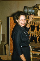 Photographer's wife, Lois Foley Steinmetz, in front of a photographic film drying cabinet.