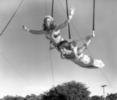 Young people on a trapeze bar at the Sarasota High School Sailor Circus.
