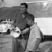 Gene Rayburn showing instant camera photograph to a boy at the Cristiani Brothers Circus during rehearsal for NBC-TV in Sarasota, Florida.