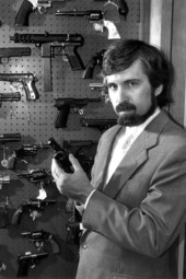Gary Kleck stands in front of a display of weapons - Tallahassee, Florida