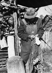 Daniel Crews mending overhalls with feed sack string - Baker County, Florida