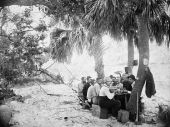 Men eating a meal while on hunting and fishing expedition