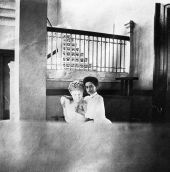Staff member holding bust in front of interior staircase.