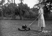 Mrs. Irene Watson, home demonstration club member pushing a lawn mower on "clean-up" day - Lamont, Florida