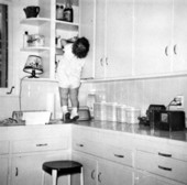 Child looking in cabinets..