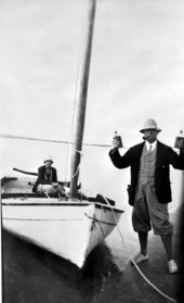 Man standing next to boat holding whiskey flasks - Fort George Island, Florida