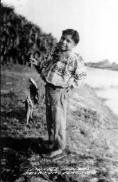 Seminole boy with caught fish - Brighton Reservation, Florida.